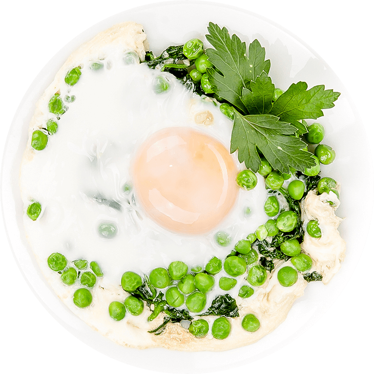 Fried eggs on garden peas and spinach