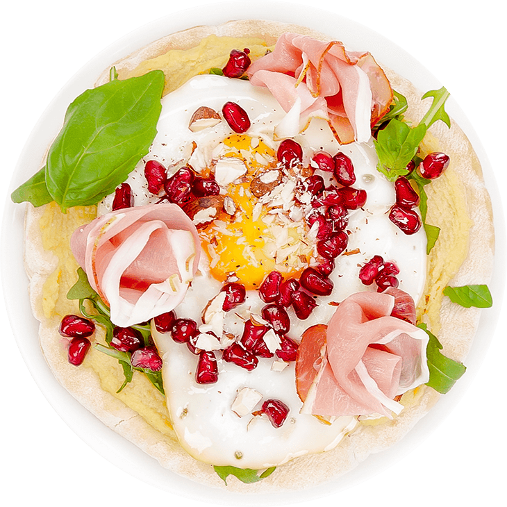 Pita bread with hummus, Prosciutto ham, fried egg and rocket