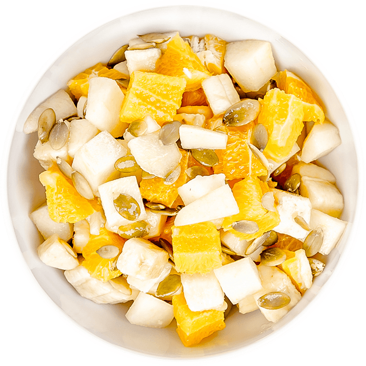 Fruit salad with banana, orange, pear and pumpkin seeds
